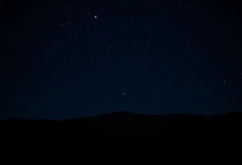 Fototapeta premium Vast, inky black night sky, silhouetted mountains and trees, copy space, trees silhouette