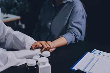 female doctor or woman medical staff holding hand, working hand in hand, giving encouragement to patient or relative of patient; concept of woman health care worker, doctor, therapist, medical worker