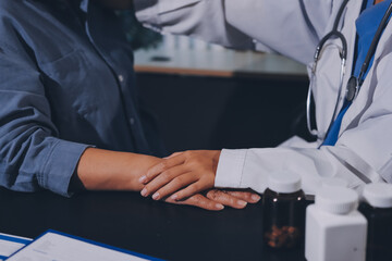 female doctor or woman medical staff holding hand, working hand in hand, giving encouragement to patient or relative of patient; concept of woman health care worker, doctor, therapist, medical worker