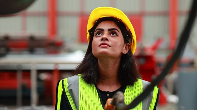 remote control overhead crane : Indian female engineer worker working control sheet metal roof machine at metal sheet profiling factory. Industrial production. Maintenance of factory machinery