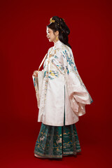 Girl wearing Chinese Ming Dynasty Hanfu costume against a red background