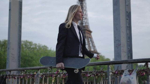 Businessman walking with skateboard in paris near eiffel tower