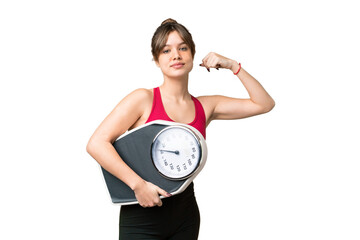 Young girl over isolated chroma key background holding a weighing machine and doing strong gesture