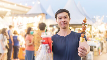 An Asian young man travels with street food.