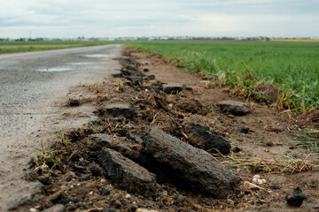 A road with a large crack in it and a grassy area next to it