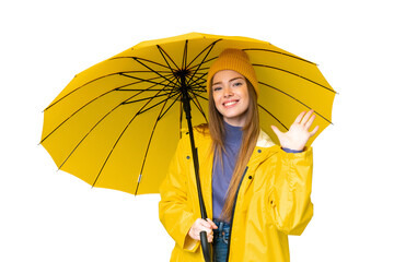 Young pretty woman with rainproof coat and umbrella over isolated chroma key background counting...