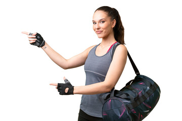 Young sport woman with sport bag over isolated background pointing finger to the side and presenting a product