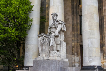 Classical Stone Statue of Historical Figure Between Massive Building Columns at Historical Site