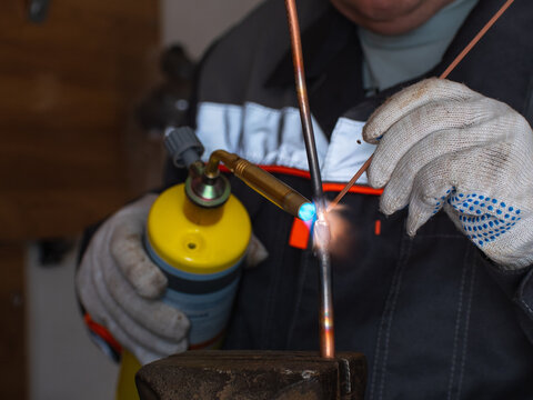worker solders copper pipes with mapp gas