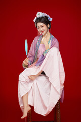 Beautiful woman wearing Chinese Ming Dynasty Hanfu with hairpin and flower ornaments on red...