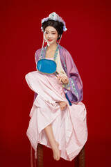Beautiful woman wearing Chinese Ming Dynasty Hanfu with hairpin and flower ornaments on red...