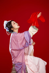 Beautiful woman wearing Chinese Ming Dynasty Hanfu with hairpin and flower ornaments on red...