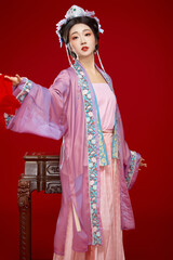 Beautiful woman wearing Chinese Ming Dynasty Hanfu with hairpin and flower ornaments on red...
