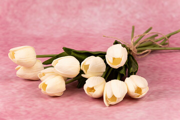 Ramo de tulipanes blancos sobre fondo rosa.