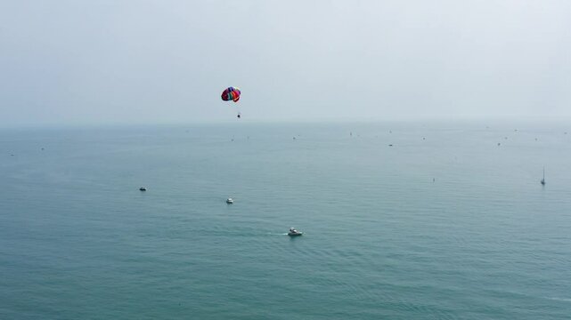 Sea bay on a summer day. Sea bay with sailing yachts aerial view. Parachutist flies after a yacht