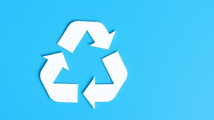A clean white recycling symbol on a bright blue background represents environmental responsibility and sustainability.