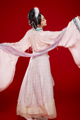 Beautiful woman wearing Chinese Ming Dynasty Hanfu with hairpin and flower ornaments on red...