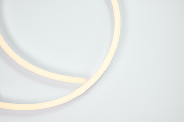 Flexible warm white led tape glowing on white background.