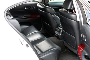 Close-up of the rear seats of a lux car. Rear passenger seats of matte black genuine leather inside...