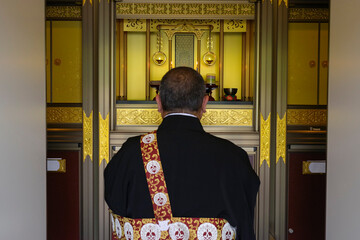 納骨堂の仏壇で合掌をするお坊さん