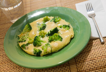 Wholesome breakfast. omelet with broccoli on green plate