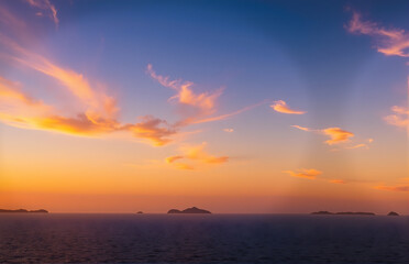 Naklejka premium Beautiful Sunset over the Ocean with Islands Silhouette