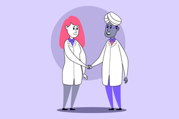 Two healthcare professionals standing together, smiling and shaking hands in friendly manner. Professionalism and teamwork, healthcare collaboration concept