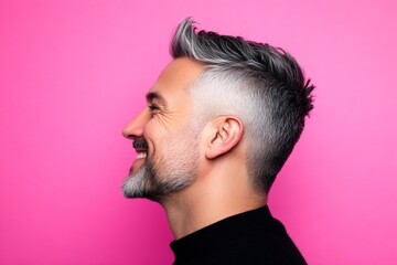Fototapeta premium Pink solid background. Creative of style for aging men. Trendy men's high fade haircut - midlife arabian man with short hair. A joyful and radiant male expressing confidence.