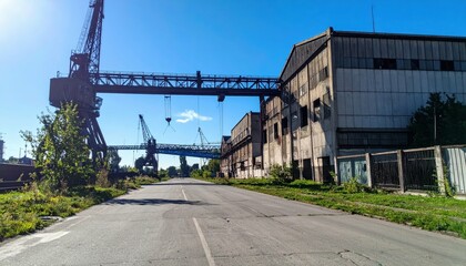 Antique Warehouse with Overhead Cranes Under Harsh Midday Sun