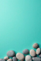 Smooth stones arranged on a teal background, a tranquil scene for serenity and contemplation