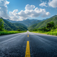 Naklejka premium Asphalt road leading to green mountains under a blue sky