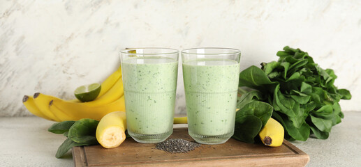 Glasses of fresh spinach smoothie with bananas and chia seeds on white background