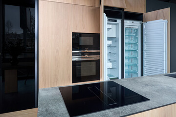 Contemporary fitted kitchen interior with minimalist flat design with wooden striped cabinets,...