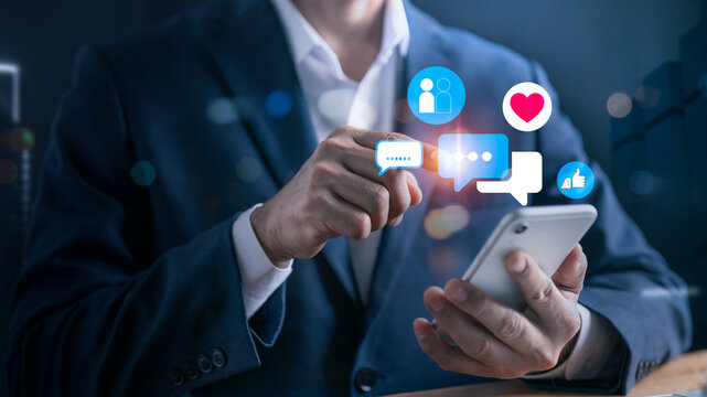 Digital business concept with social media interaction, businessman touching chat bubble and heart icon, online presence, mobile engagement, social networking and branding
