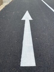 White arrow on a freshly paved street