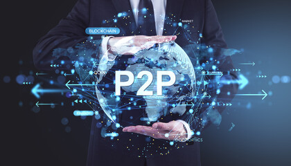 Businessman holding digital globe with P2P text and blockchain financial network concept on futuristic blue background with glowing data points.