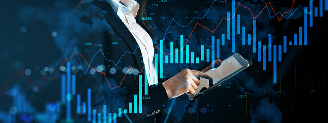 Businesswoman using tablet with digital financial data and bar graphs on dark global background, representing technology and economic concept.