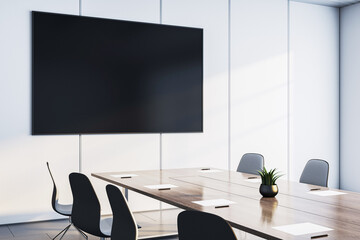 Modern conference room with large wall-mounted TV screen, wooden desk, and black chairs in clean corporate office interior setting. 3D Rendering