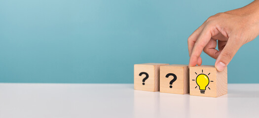 Creative thinking, creative, idea, problem solving, innovation. A man choose wooden cube with idea light bulb among question marks icon. Success business