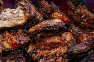 A close-up of freshly grilled meat pieces stacked together, featuring crispy, charred edges and tender, juicy textures ideal for BBQ and culinary visuals.