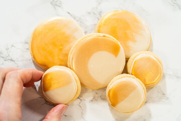 Hand Holding Gold-Painted Sugar Cookie with Royal Icing