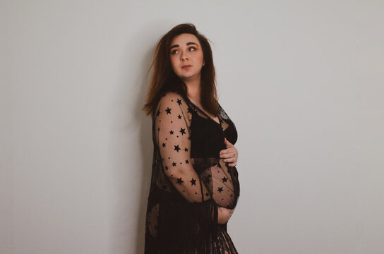Femme enceinte en sous v&ecirc;tement noir sur fond blanc