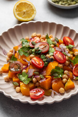 Vibrant butternut squash salad with cherry tomatoes and chickpeas. Vegan food