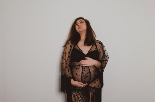 Femme enceinte en sous v&ecirc;tement noir sur fond blanc