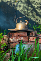 Steel kettle on a homemade brick stove outside. The rustic old way to boil water and cook food over...