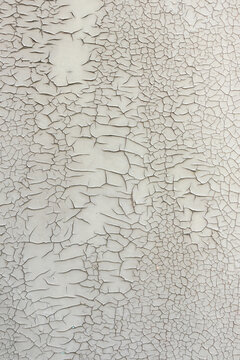 Cracked paint on a gray surface. Natural light background with many dark cracks