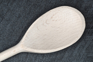 Wooden spoon displayed on dark stone surface, highlighting craftsmanship and design intricacies