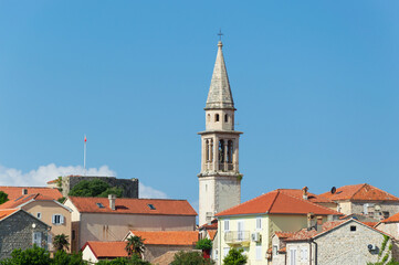 Fototapeta premium View of the old historic town with church, tiled roofs, general plan against the blue sky