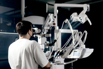 Dentist examining teeth condition using a surgical digital microscope in a dental clinic. Concept...