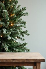 Rustic Wooden Tabletop Beside a Decorated Christmas Tree with Soft Lighting and Frosty Branches